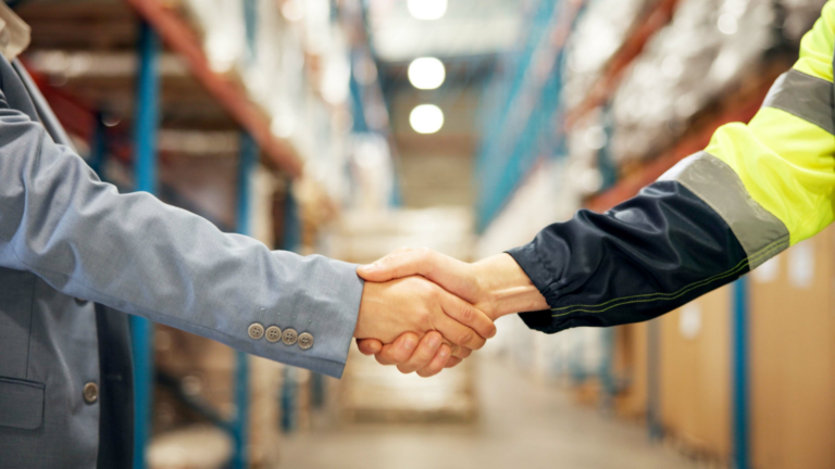 Business handshake in a warehouse distribution center